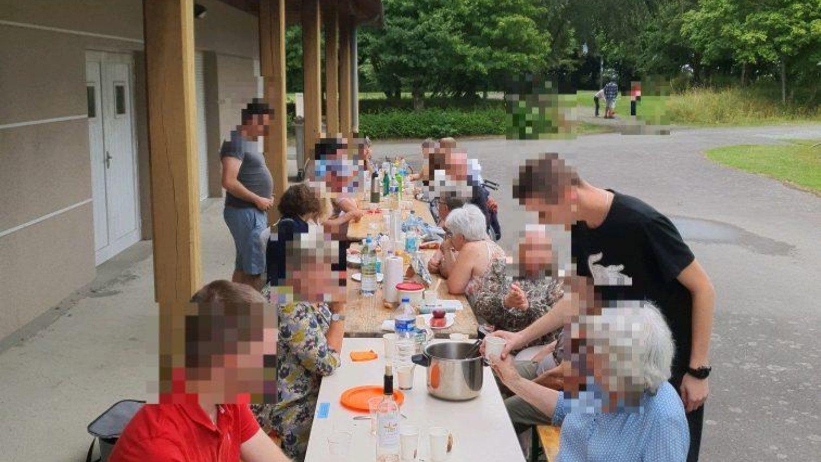 Membres de l'association déjeunant sur des tables de picnic dans le parc du Grand Domaine à Saint Malo