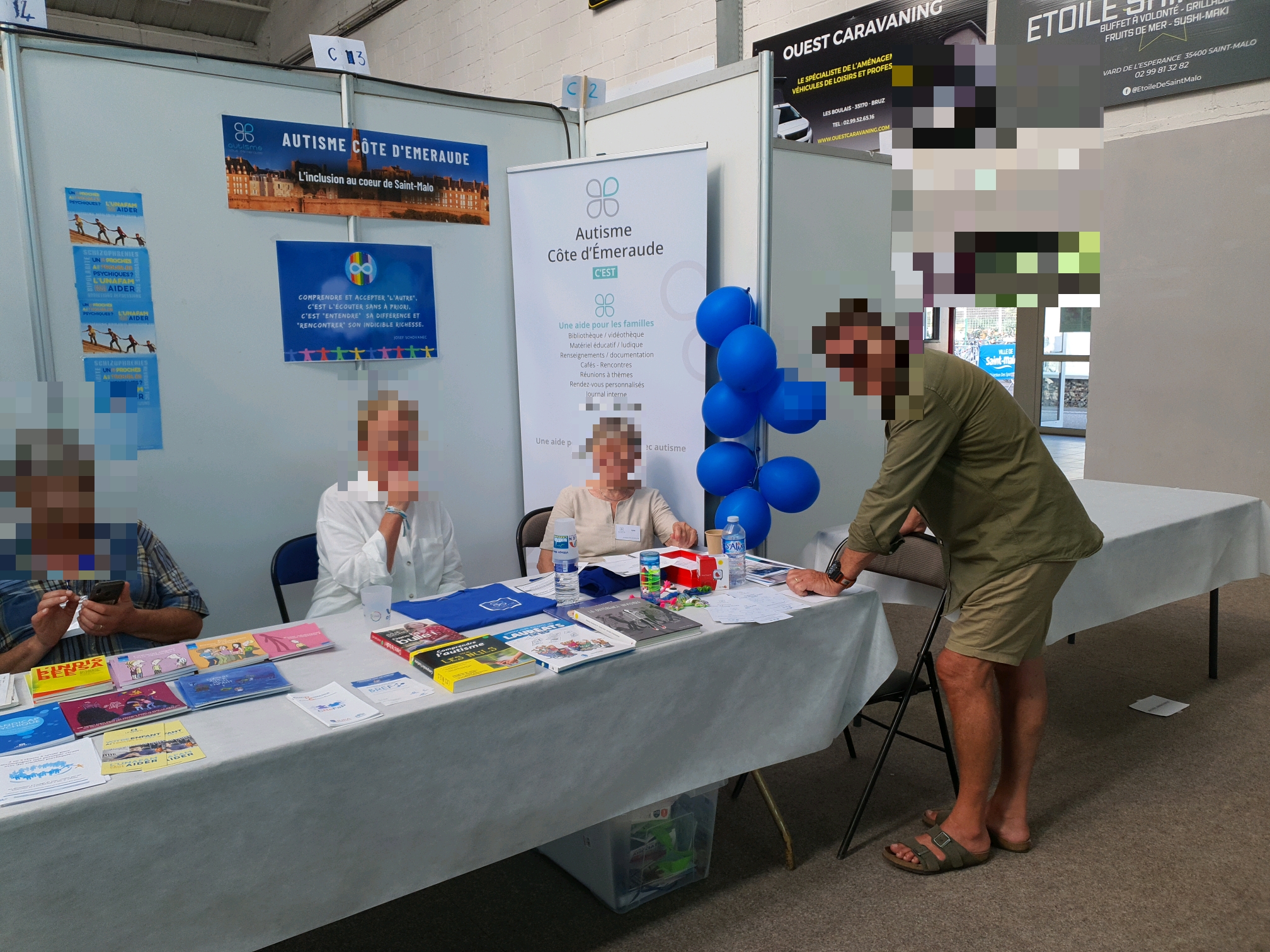 Deux bénévoles tiennent le stand d'Autisme Cote d'Emeraude au village des associations de saint malo et répondent aux questions d'un visiteur